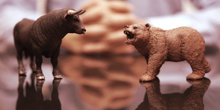bull bear figurines in front of folded hands gID 4