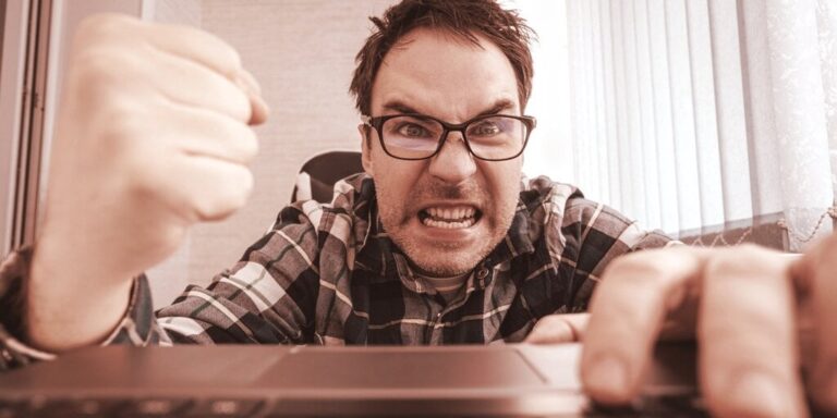 angry man shaking fist at laptop gID 4