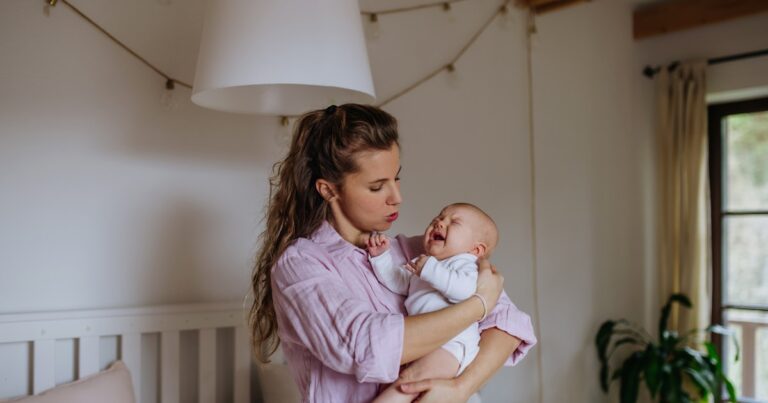 mother holding crying newborn