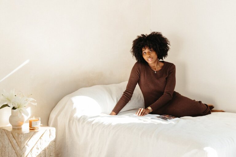 woman reading on bed with candle