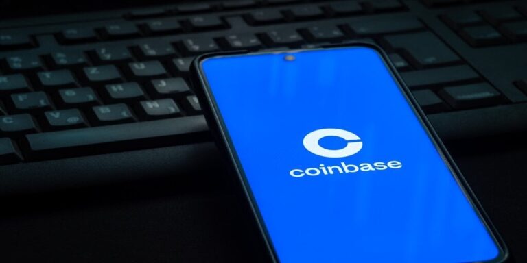 Coinbase cryptocurrency exchange logo on smartphone screen laying on computer keyboard gID 7